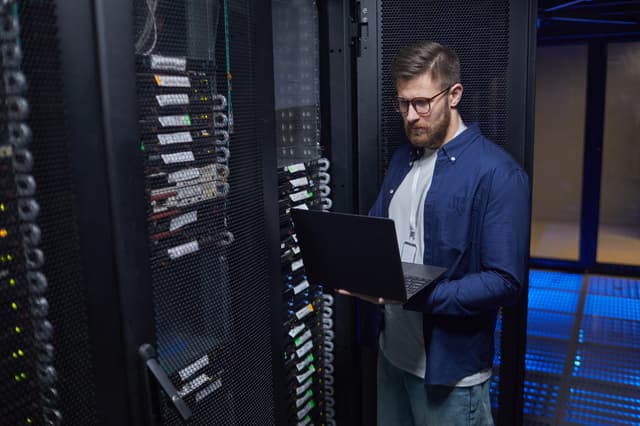 IT specialist checking network equipment in a server room